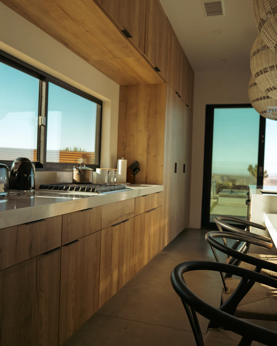 Modular kitchen in warm timber laminate with a window over the counter